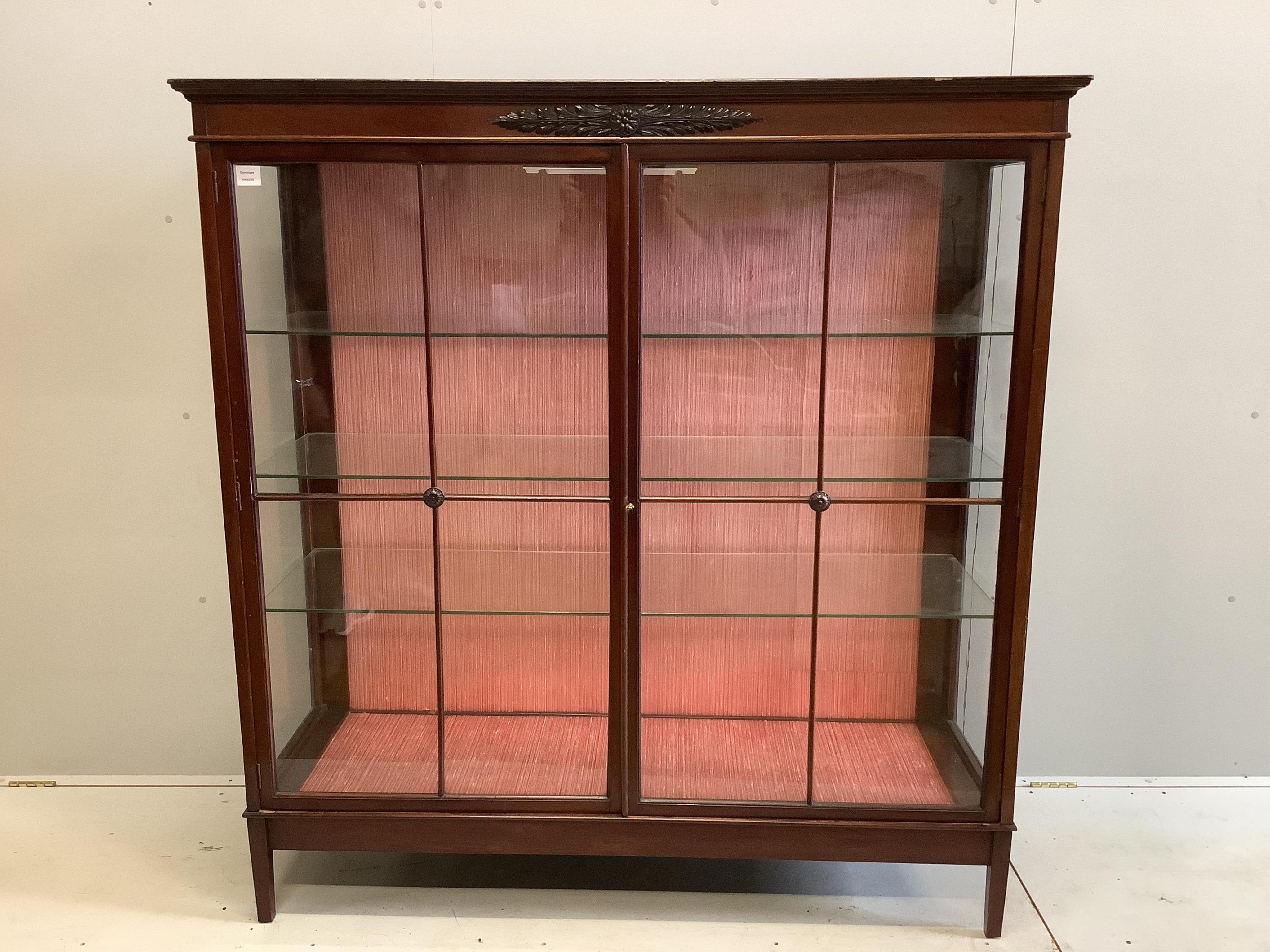 An early 20th century mahogany two door glazed display cabinet, width 148cm, depth 46cm, height 156cm. Condition - fair